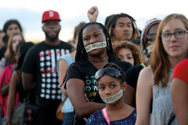 Demonstrators stand with tape reading: “ I can’t breathe” to protest police abuse on December 7, 2014 in Miami, Florida.