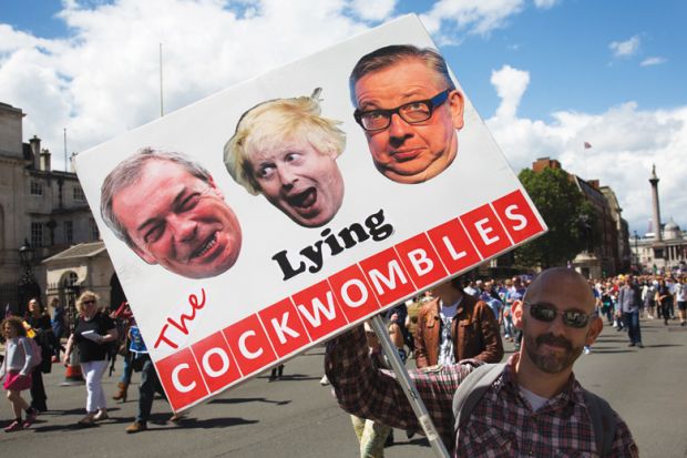Brexit demonstrator holding sign of Nigel Farage, Boris Johnson and Michael Gove