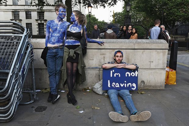 A young couple painted as EU flags protest on outside Downing Street against the United Kingdom's decision to leave the EU following the referendum