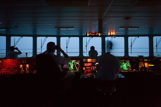 Captain and officers in silhouette looking out of window in the bridge of a ship. To illustrate the search is on for a new chief executive to lead the Office for Students.