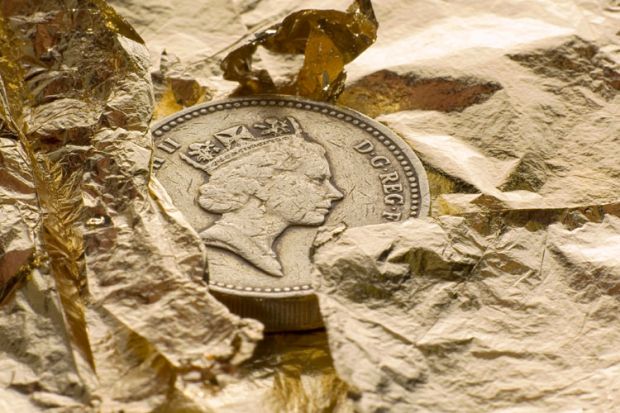 British pound coin on gold leaf British pound coin on gold leaf