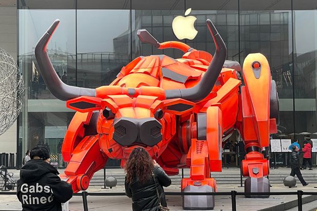 People look at a bull statue set up in front of an Apple store at Sanlitun, 2021 in Beijing, China. To illustrate if the academy can rein in Big Tech.