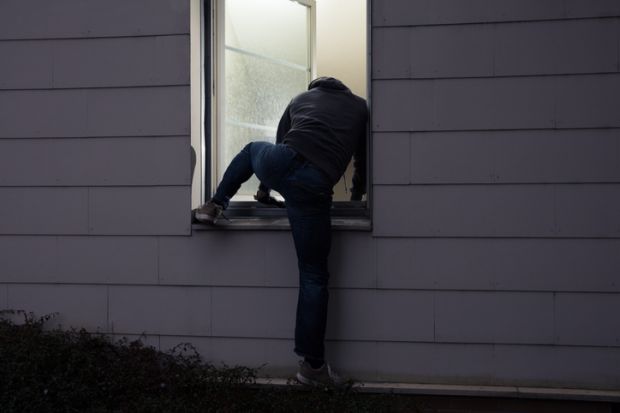 Burglar climbing in a window