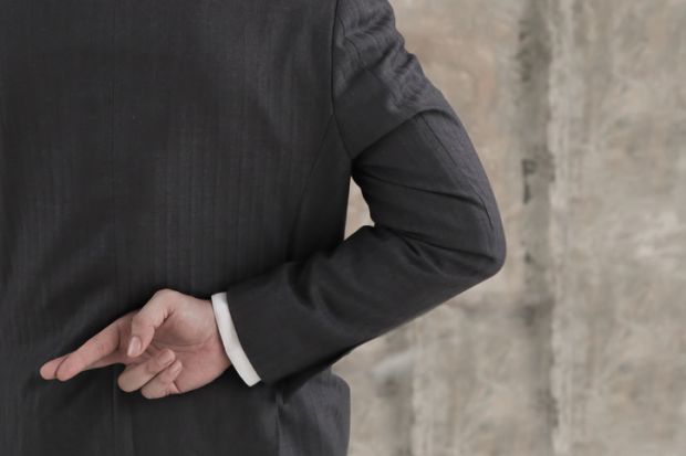 Businessman with his fingers crossed behind his back