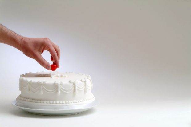Cake with hand taking cherry on top