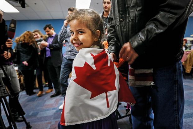 Syrian child wrapped in Canadian flag