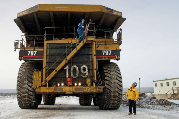 Canadian workmen operating large construction vehicle
