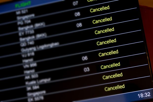 An airport departure board with lots of flights cancelled illustrating an opinion article about cancel culture