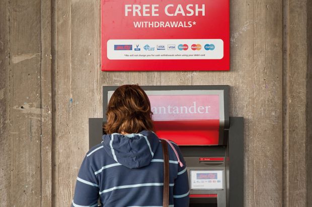 Student using ATM cash point machine