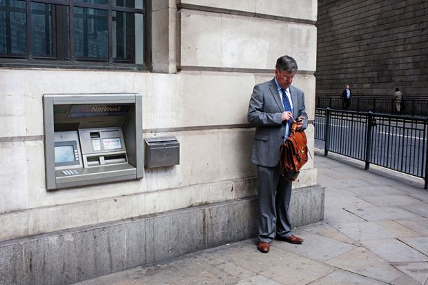 Man standing next to cash machine