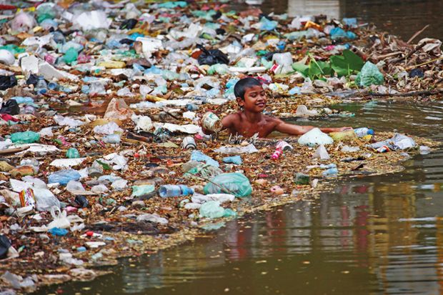 Child swimming in plastic rubbish