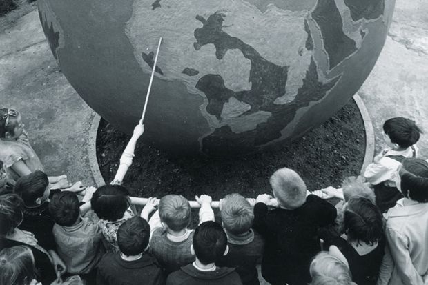 Children viewing globe during geography lesson Children viewing globe during geography lesson