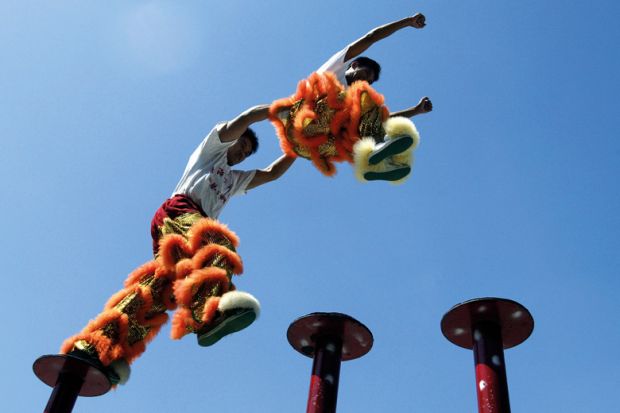 Chinese acrobatic performers jumping between poles