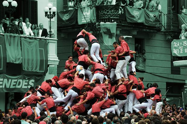 People fall as they attempt to form a “castell” during an exhibition of the human towers, or castells, in Vilafranca del Penedes, 2016