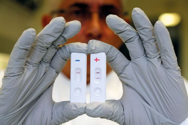 Researcher holds Ebola diagnostic tests