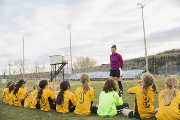 Coach talking to girls soccer team
