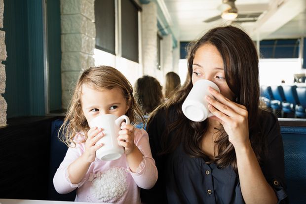 Woman and little girl drinking coffee