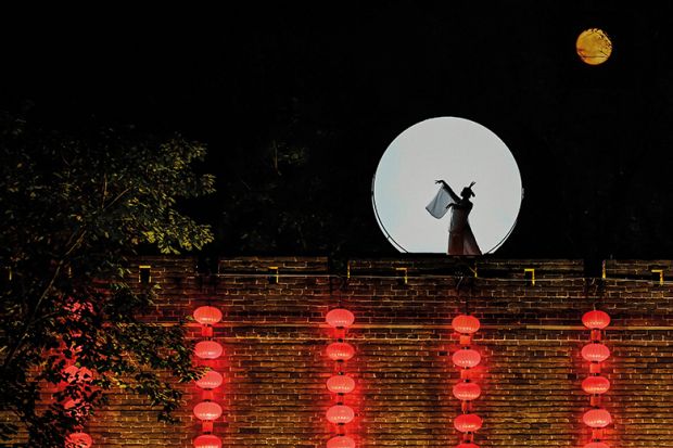 Asian woman on a wall in moonlight