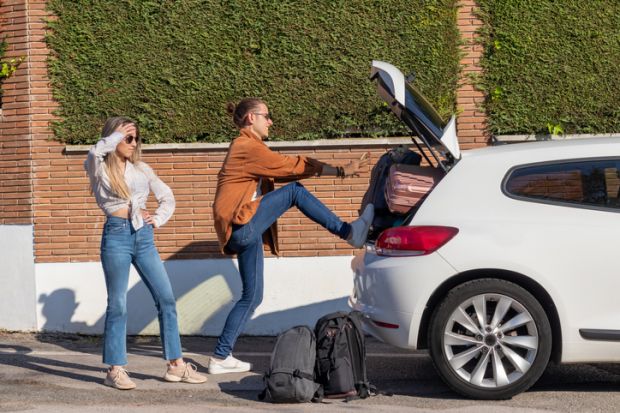 A couple try to cram suitcases into a small car, symbolising abstracts