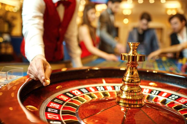 Croupier holds a roulette ball in a casino