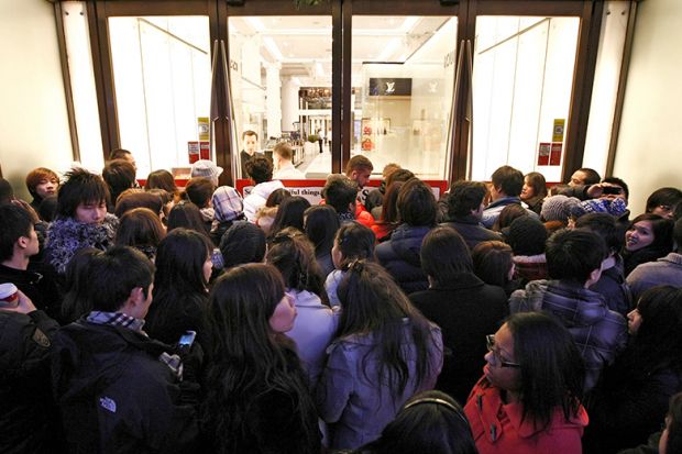Shoppers wait outside Selfridges as the store opens it doors on the first day of its winter sale on Boxing Day. To illustrate that some universities are enrolling hundreds of research students despite warnings.