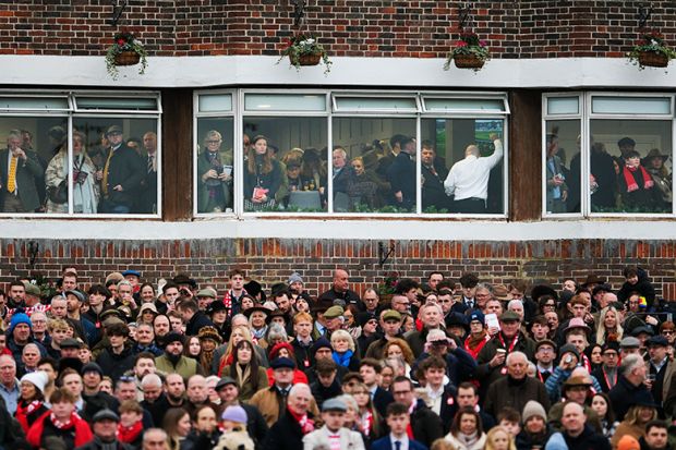 A busy crowd, with some in a hospitality area, at the races at Kempton Park in Sunbury, England. To illustrate a two tier workforce.
