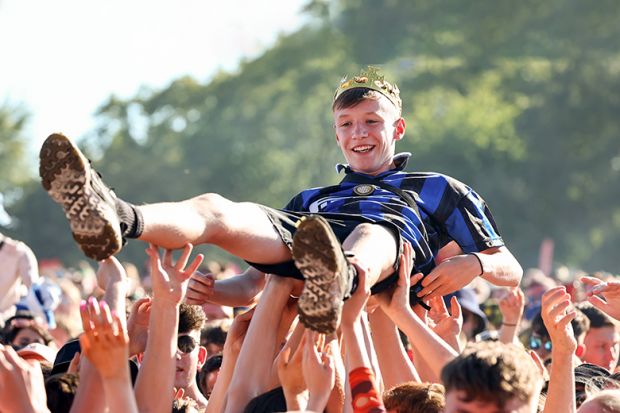 A music fan wearing a crown crowd surfs at the TRNSMT Festival. To illustrate academic communities in all parts of the UK helping rising stars of humanities and social sciences to shine. A music fan wearing a crown crowd surfs at the TRNSMT Festival. To illustrate academic communities in all parts of the UK helping rising stars of humanities and social sciences to shine.