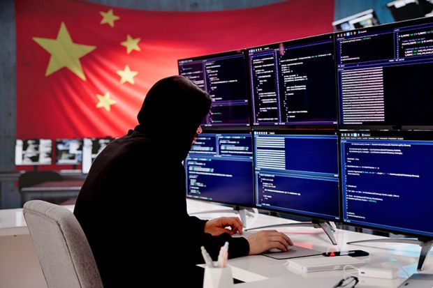 Cybersecurity expert coding with Chinese flag displayed In background. To illustrate that universities have been told by MI5 to review their ties with a Chinese research institute after spy warning.