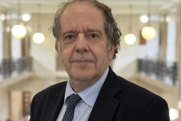 A man in a suit with grey hair facing the camera