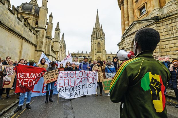 A student in an African-style jumper speaks to demonstrators outside University of Oxford’s All Souls College