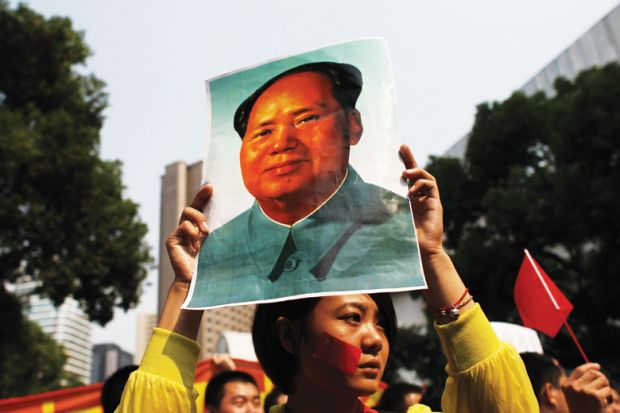 Demonstrator holding poster of Mao Zedong (Mao Tse-tung), Shanghai