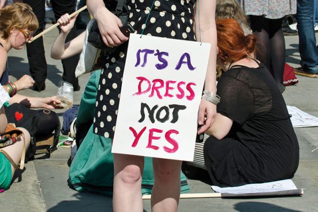 Demonstrator wearing 'It's a dress, not yes' placard