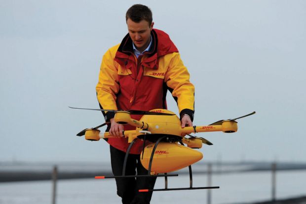 DHL employee prepares PaketKopter drone for delivery