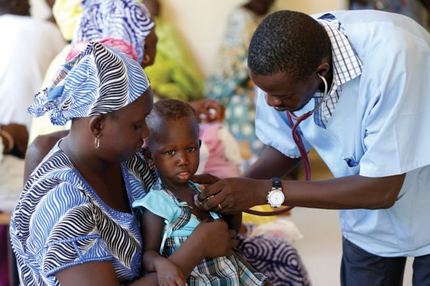 Doctor examining young child patient, Dakar, Senegal