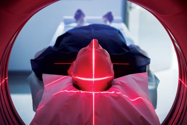 Elderly man lying down in Body CT (CAT Scan) machine