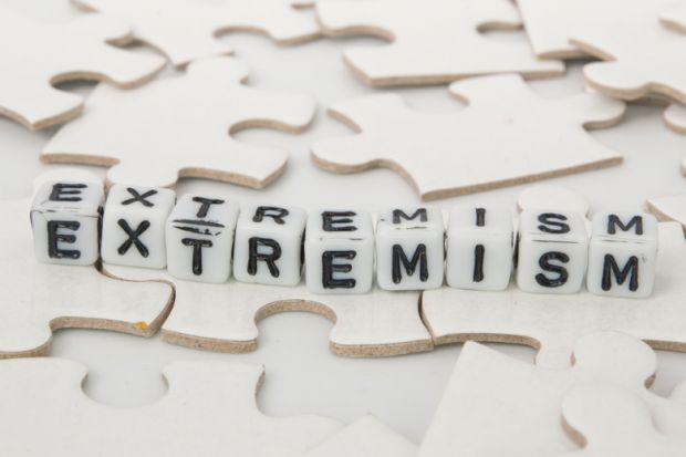 'Extremism' spelled out in letter blocks on jigsaw 'Extremism' spelled out in letter blocks on jigsaw