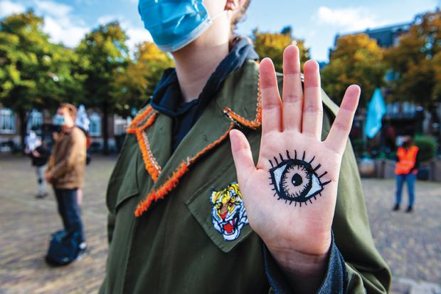 XR activists standing up with eyes painted on placards in front of the House of the Parliament where the New Extinction Rebellion campaign has started in The Hague, Netherlands on September 1, 2020