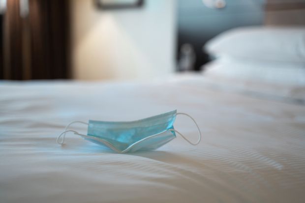 face mask on hotel bed quarantine