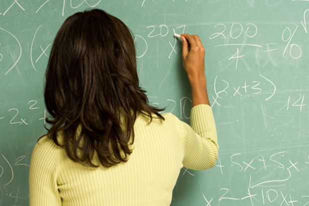 Female lecturer writing on classroom blackboard
