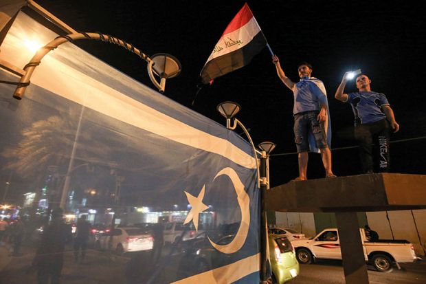 Iraqis wave their national flag and the flag of the Iraqi Turkmen as they celebrate in the city of Kirkuk in October 2017