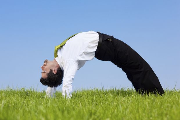 A flexible businessman bends over backwards