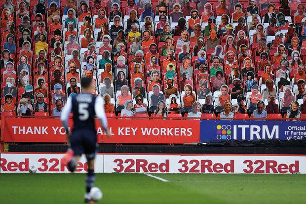 Cardboard cutout fans during football match Soccer player in front of carcboard cutout crowd. Shows diverse supporters to relate to subject diversity improving globally.