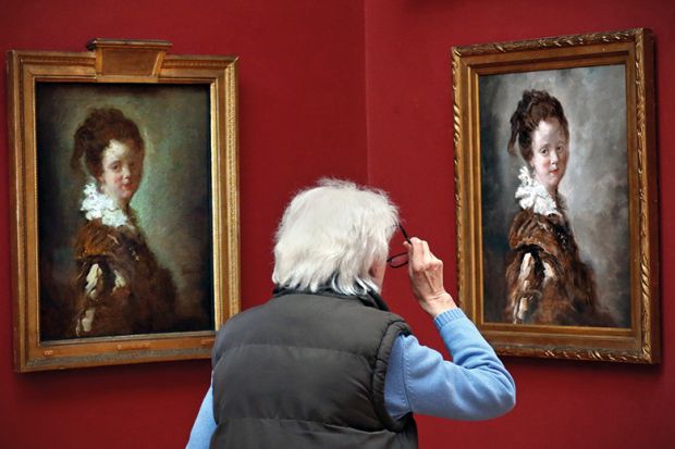 A visitor views a replica of Jean-Honore Fragonard’s 18th century painting ‘Young Woman’ (R) as the original hangs to its left on April 28, 2015 at Dulwich Picture Gallery in London, England.