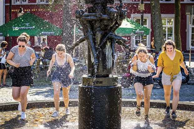 Women cool off in a fountain in Maastricht, on August 8, 2020