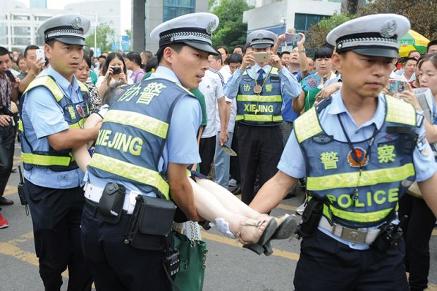 Gao kao exam in China. Policemen rescue woman who fainted