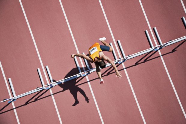 Runner jumping hurdles on track Runner jumping hurdles on track