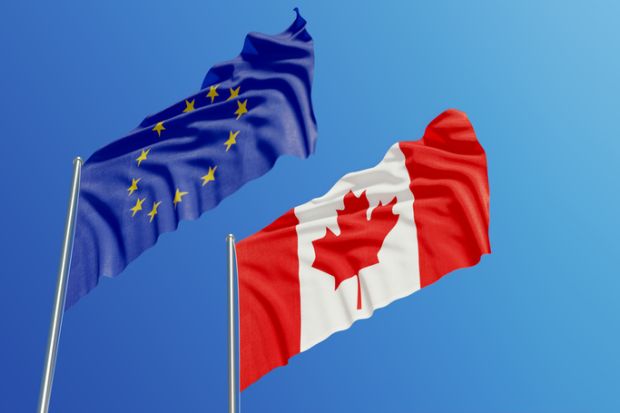 The Canadian and EU flags in the sky