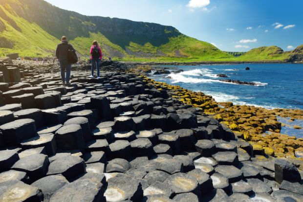 Two tourists walking at Giants Causeway Two tourists walking at Giants Causeway