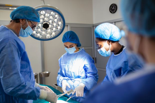 Group of surgeons in operating room with surgery equipment Group of surgeons in operating room with surgery equipment