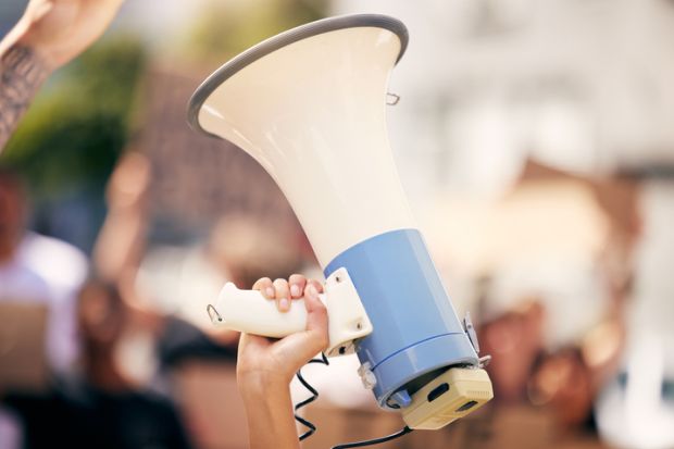 a protester holding a megaphone during a rally a protester holding a megaphone during a rally